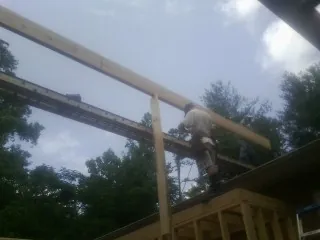 Carpenter setting a ridge beam over a new addition frame — Ice Dam Removal by Roofing Brothers in Mount Arlington