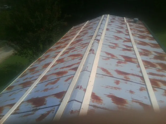 Rusted metal roof panels with new wood purlins before replacement in Mount Arlington