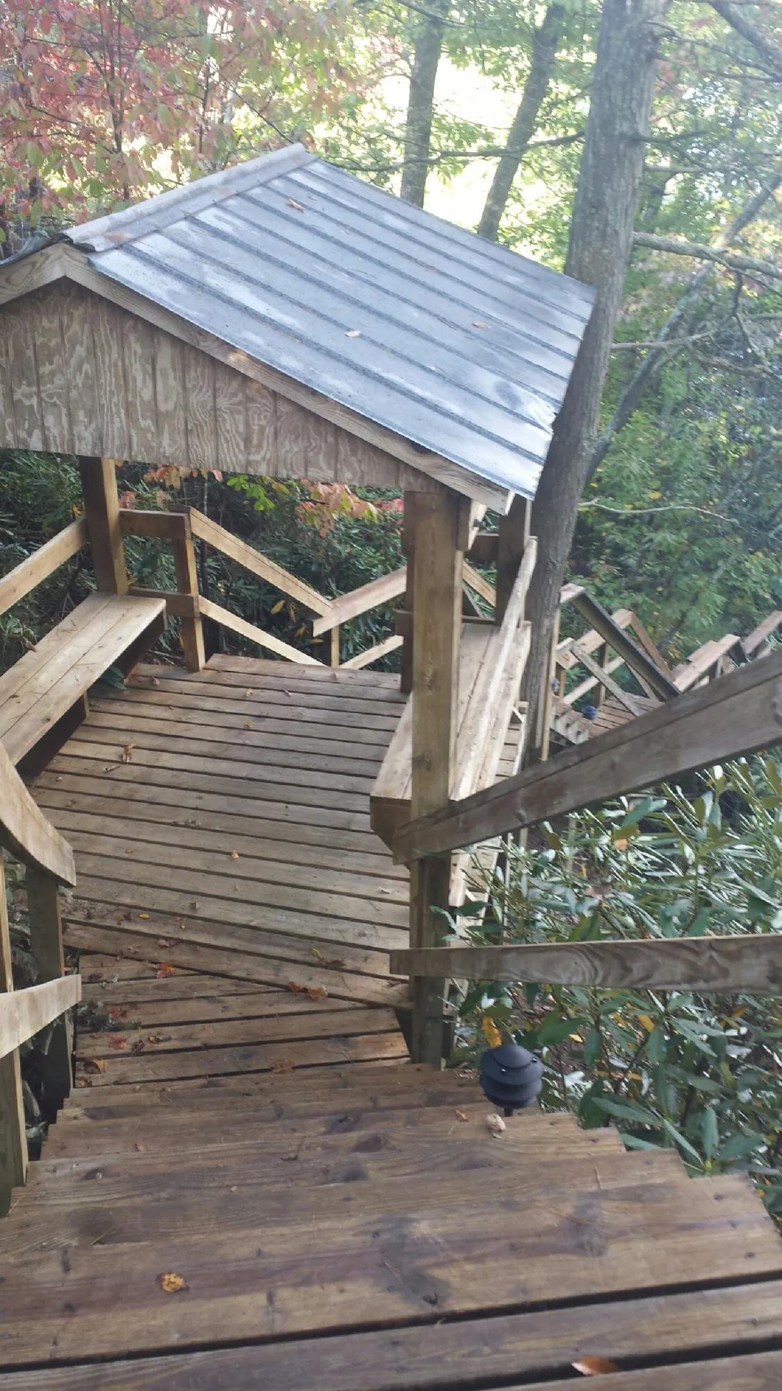 Metal roofed shelter over wooden steps on a wooded walkway — Skylight Repair & Installation work by our crew in Mount Arlington