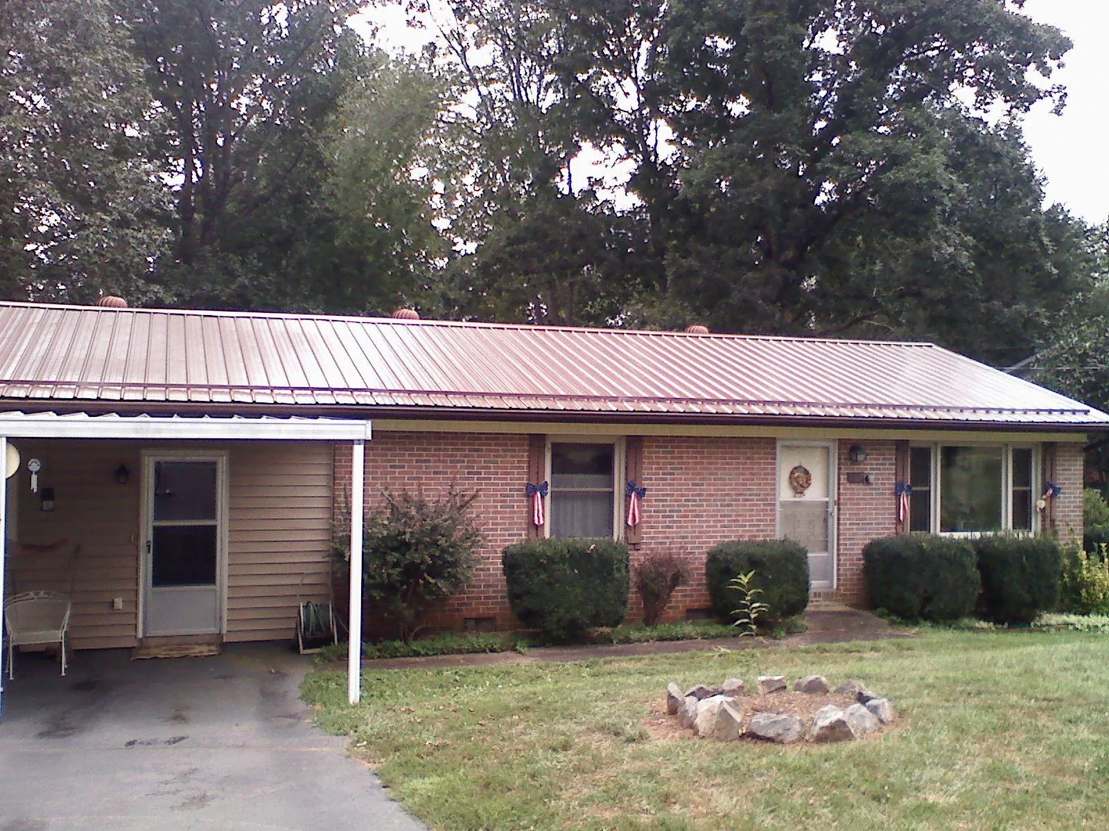 Bronze metal roof and carport on a brick ranch home — Roof Repair work by our crew in Mount Arlington